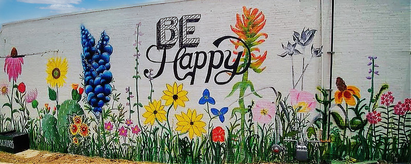 The "Be Happy" mural ... on the back wall of the ETX Brewing Company, facing South College Avenue